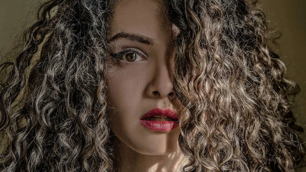woman with curly hair covering half of face